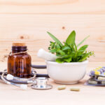 capsule of herbal medicine with stethoscope wooden background.